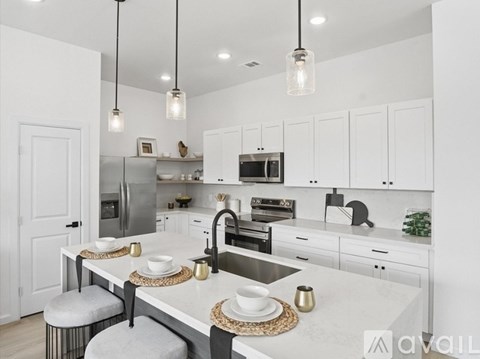 A modern kitchen with white cabinets and a marble countertop.