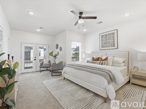 A bedroom with a large bed and a ceiling fan.
