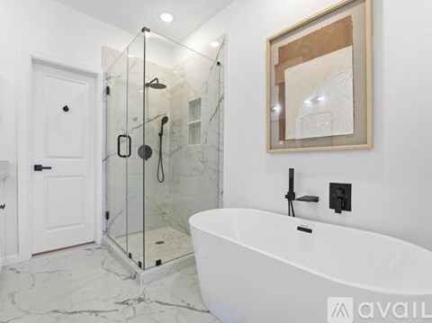 A white bathroom with a marble floor and a white bathtub.
