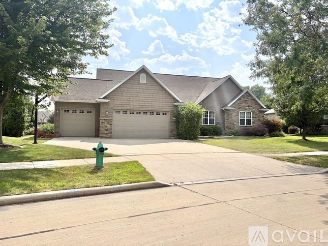 A house with a garage and a driveway in front of it.