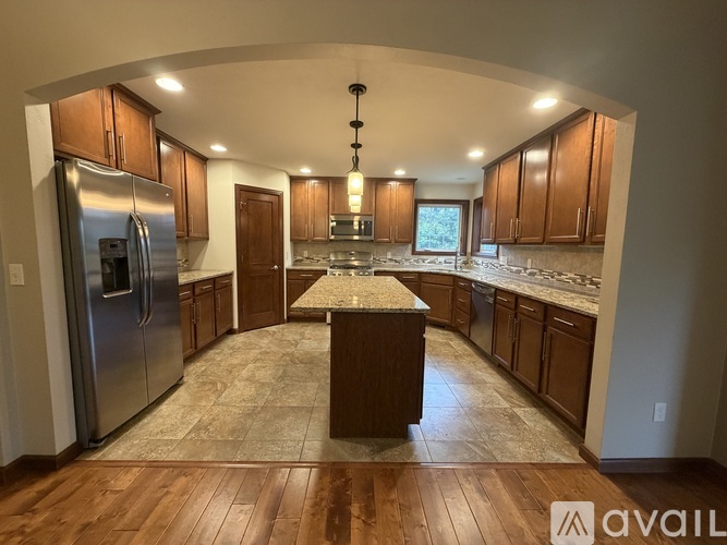 A kitchen with wooden cabinets and a granite countertop.
