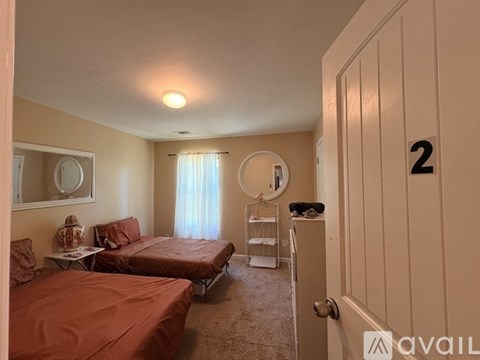 A bedroom with two beds and a dresser.