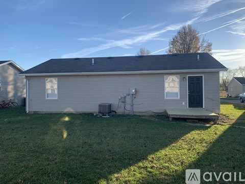 A house with a grey roof and a black door is available for rent.
