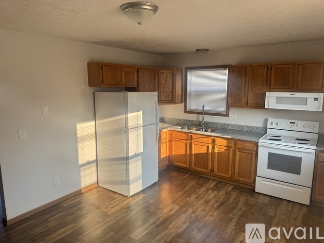 A kitchen with wooden cabinets and white appliances.