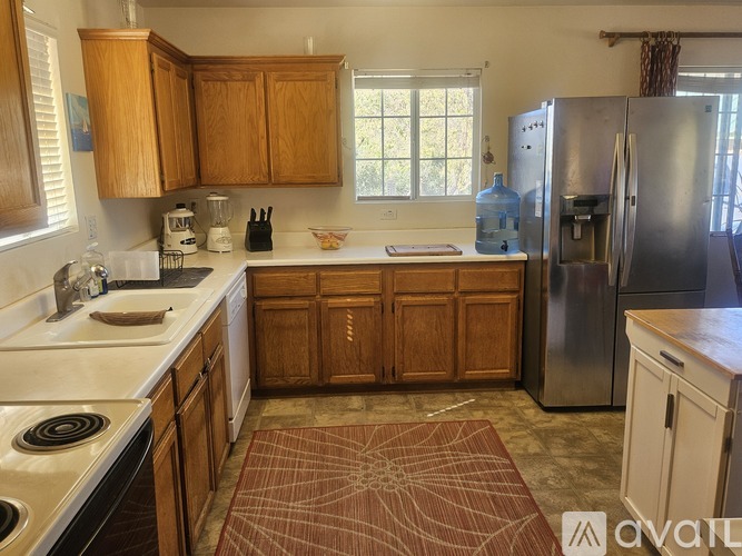 A kitchen with wooden cabinets and a stainless steel refrigerator.