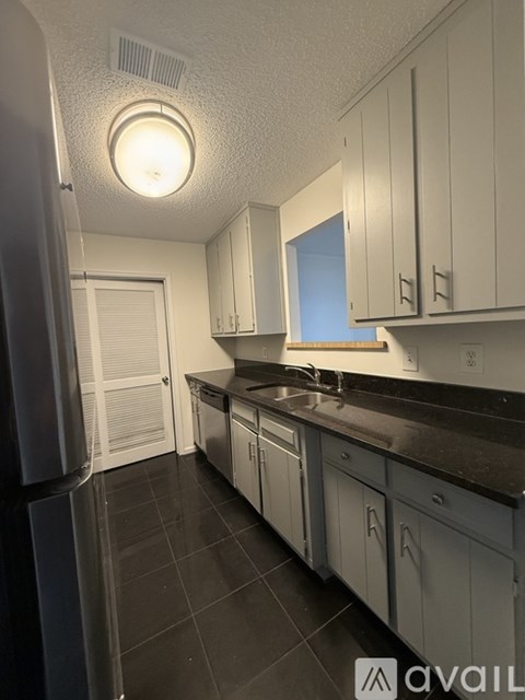 A kitchen with black countertops and white cabinets.