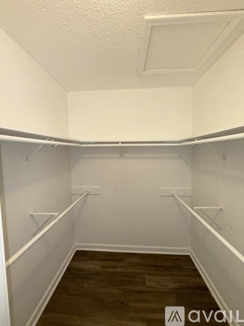 A small, empty room with wood flooring and white walls.