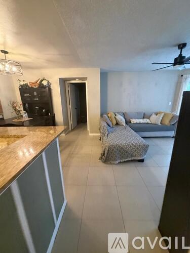 A living room with a grey couch and a wooden counter.