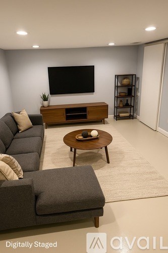 A modern living room with a grey sofa and a wooden coffee table.