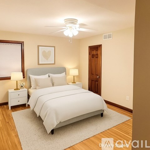 A bedroom with a bed, nightstands, and a ceiling fan.