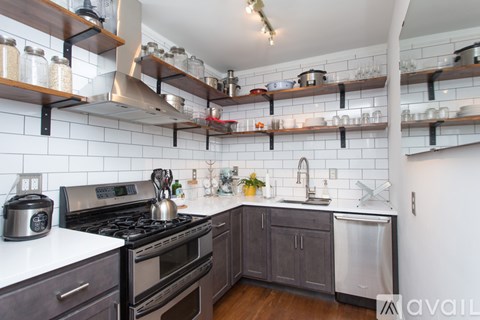 A kitchen with a stove, oven, and shelves above the counter.