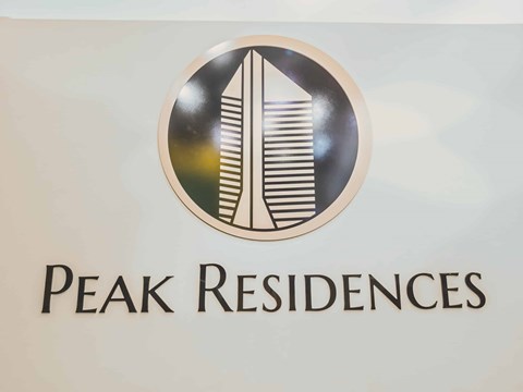 A logo for Peak Residences featuring a skyscraper.
