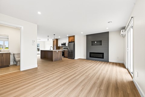 A spacious living room with a fireplace and hardwood floors.