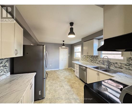 A kitchen with a black fridge and a black stove top oven.