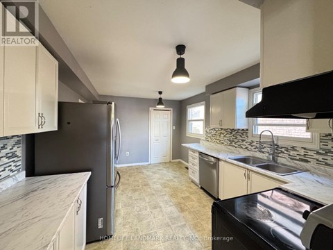 A kitchen with a black fridge and a black stove top oven.