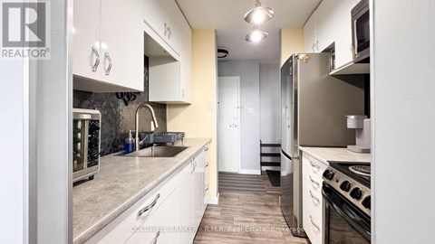 A kitchen with white appliances and cabinets.