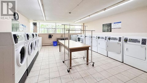 A laundry room with a table and washing machines.