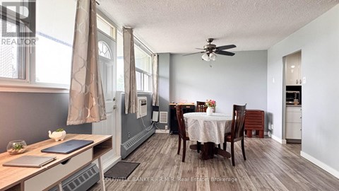 A dining room with a table set for two and a kitchen area in the background.