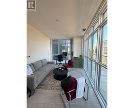A living room with a grey couch, a black coffee table, and a red chair.