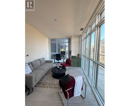 A living room with a grey couch, a black coffee table, and a red chair.