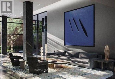 A modern living room with a grey sofa and a large blue painting on the wall.