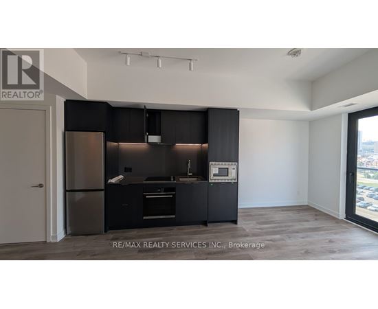 A modern kitchen with black cabinets and stainless steel appliances.