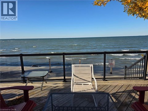 A chair and table are on a deck overlooking the ocean.