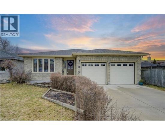 A house with a garage and a small garden in front.