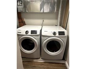 Two white front loading washing machines in a laundry room.