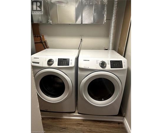 Two white front loading washing machines in a laundry room.
