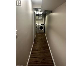 A long hallway with a washer and dryer in the background.