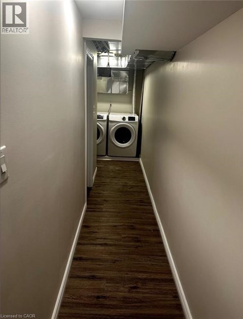 A long hallway with a washer and dryer in the background.