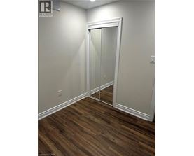 A room with a white door and wood flooring.