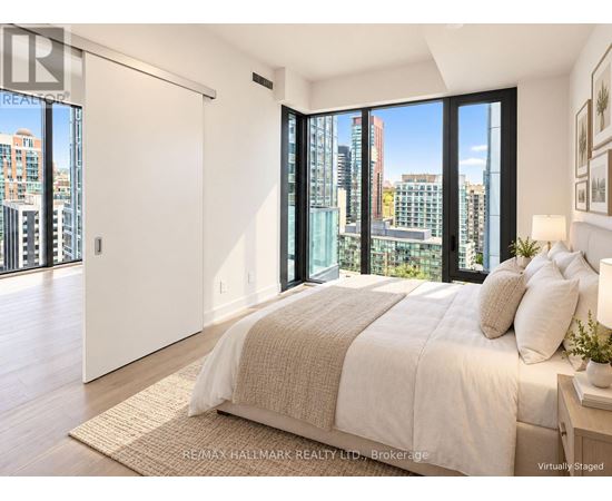 A bedroom with a large bed and a view of the city.
