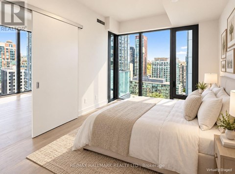 A bedroom with a large bed and a view of the city.