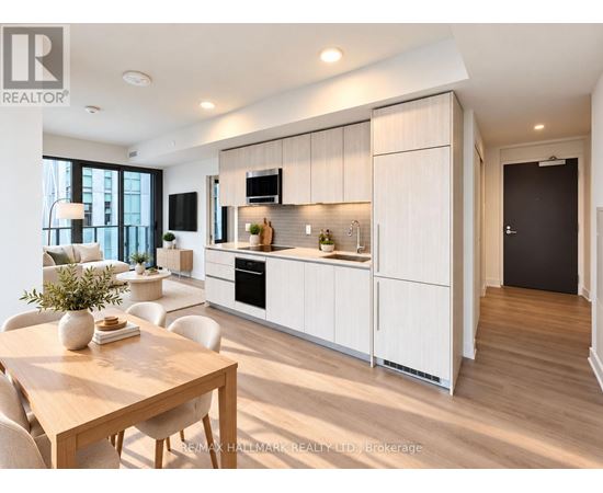 A modern kitchen with white cabinets and a wooden table.