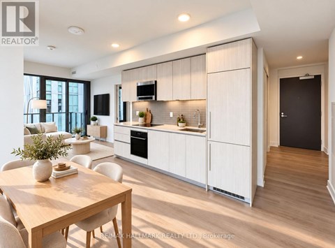 A modern kitchen with white cabinets and a wooden table.