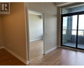 A room with a doorway leading to another room and a balcony with a glass door.