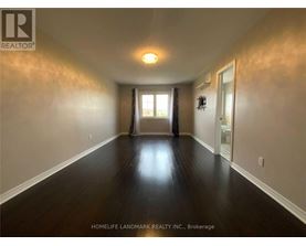A long hallway with wood floors and white walls.