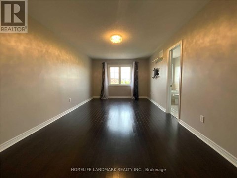 A long hallway with wood floors and white walls.