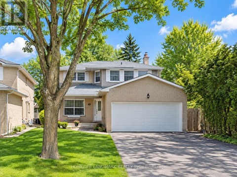 A large house with a driveway and a tree in front.