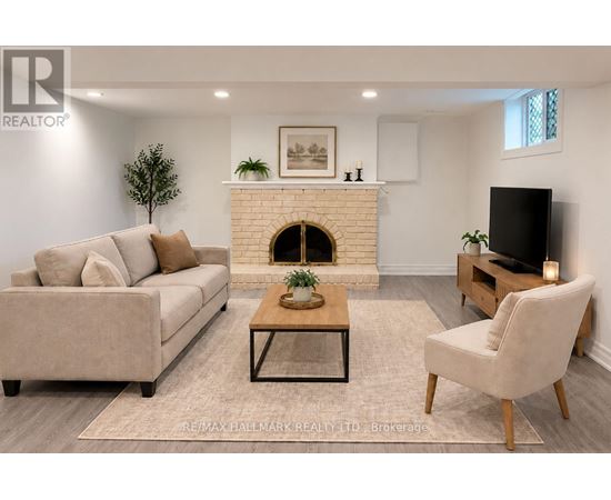 A living room with a couch, a chair, and a fireplace.