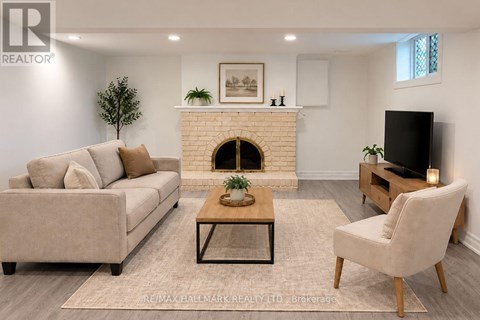 A living room with a couch, a chair, and a fireplace.