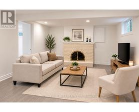 A living room with a couch, a coffee table, and a fireplace.