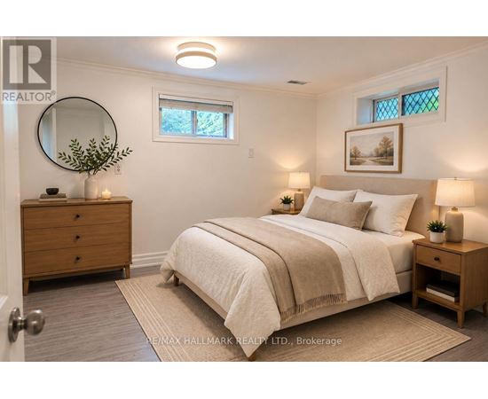 A bedroom with a bed, nightstand, and a round mirror on the wall.