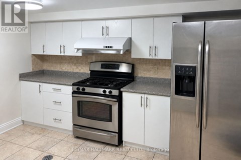 A kitchen with white cabinets and a stainless steel refrigerator.