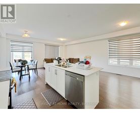 A kitchen with white cabinets and a dining table with chairs.