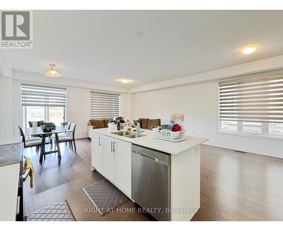 A kitchen with white cabinets and a dining table with chairs.