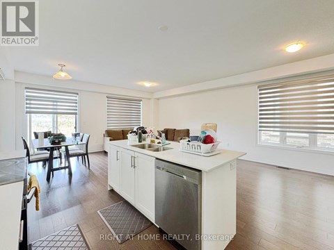 A kitchen with white cabinets and a dining table with chairs.