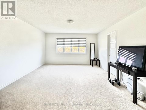 A living room with a television and a window with blinds.